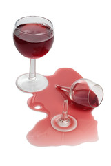 Broken glass and spilled red wine on white background