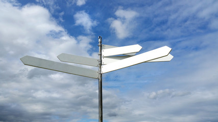 A way-marker with multiple blank signs against a blue sky with fluffy clouds