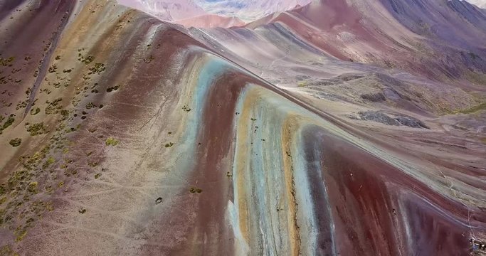 Aerial view of the Rainbow mountain and massive Andes peaks of Peru