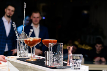 Three martini glasses with red cocktail on bar counter, shallow dof