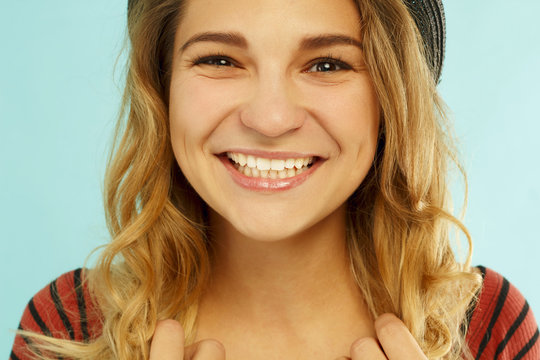 Beautiful young happy woman smiling in studio over blue background