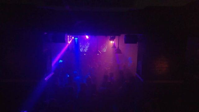 Smoky dance floor of an underground techno club with rays of light