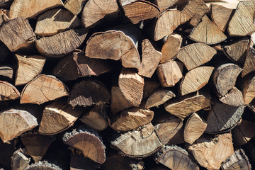 Wooden background. Firewood for the winter, stacks of firewood, pile of firewood.