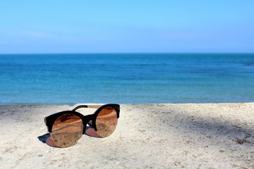 Sunglasses on a beach. Vacation vibe