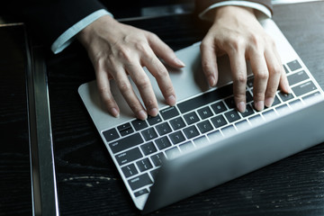 Fototapeta na wymiar business asian woman hand use laptop for work on dark wood table top