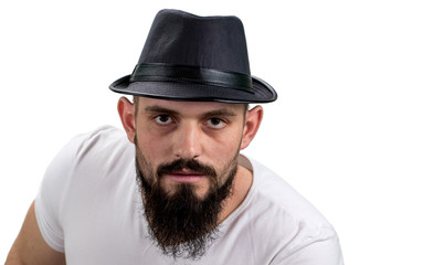 severe bearded man in hat looking at camera isolated on white background. With copy space