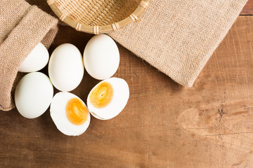 salted duck egg with utensil on old wooden table in kitchen, top view. asian style food preservation concept.
