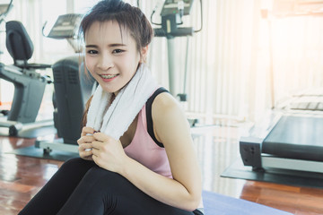 health concept with woman in sport wear relax and break from exercise in fitness center