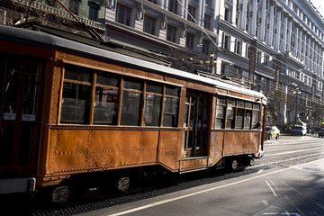 Fototapeta na wymiar Old Vintage Looking Passenger Commuter Street Car Travels along Busy Market Street in Downtown San Francisco