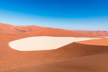 Fototapeta na wymiar Sossusvlei Namibia, clay and salt pan surrounded by majestic sand dunes. Namib Naukluft National Park, main visitor attraction and travel destination in Namibia.
