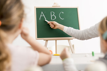 Kids Pay Attention as Adult Teaches ABC's with a Chalkboard