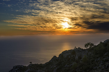Fototapeta premium Incredible Turkey, the sunset over the sea, in the sky amazing clouds and an unusual picture of them, in the foreground the road leading to the sea, and to the sea the reflection of the sun