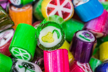 Colorful candy sweets close up, selective focus. Different tastes and drawings of fruits on candies, pear taste in front, made in prague