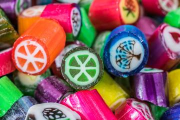 Fototapeta na wymiar Colorful candy sweets close up, selective focus. Different tastes and drawings of fruits on candies, Lime taste in front, made in prague
