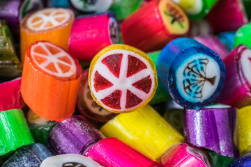 Colorful candy sweets close up, selective focus. Different tastes and drawings of fruits on candies, grapefruit taste in front, made in prague