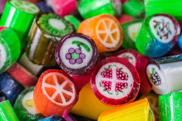 Colorful candy sweets close up, selective focus. Different tastes and drawings of fruits on candies, strawberry taste in front, made in prague