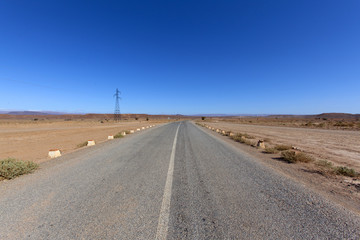 moroccan rocky desert landscape with plants and mountain range, assa-zag, Road in the desert