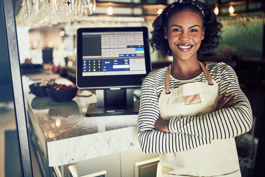 Smiling African Waitress Standing At The Counter Of A Restaurant