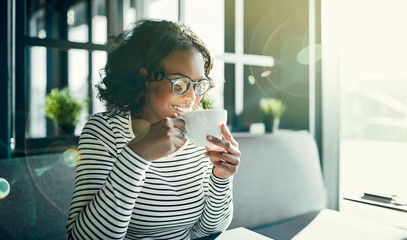 Young African woman enjoying the aroma of her coffee