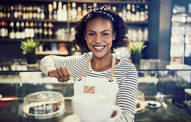 Young cafe barista offering up a fresh cup of coffee