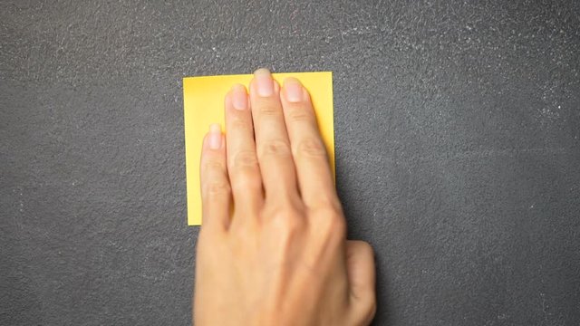 Closeup woman's hand sticking note with number "1" on the blackboard - video in slow motion