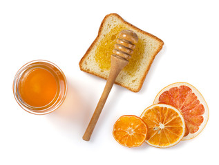 glass jar of honey and bread on white
