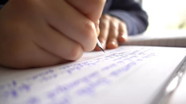 Child hands writing a letter, close up slow motion