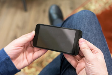 Closeup photo man hold and watching video on smartphone, horizontal wide screen orientation. - obrazy, fototapety, plakaty