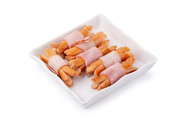 Small sausages wrapped in a blanket of smoked streaky bacon isolated on white background