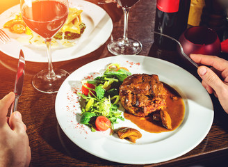 Delicious fish served with tomatoes, lemon and herbs on the wooden board. Top view, flat lay