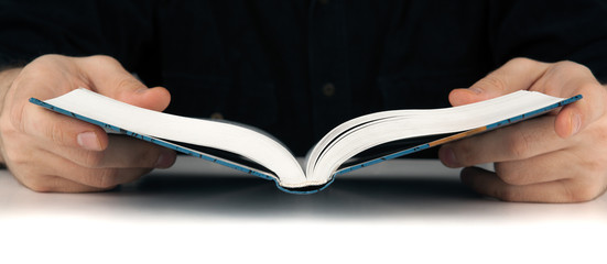 Man's hands and man looking for something in the book