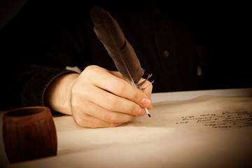 writer holds a fountain pen over writing paper and the writing poems