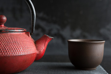 Red iron teapot on dark color background