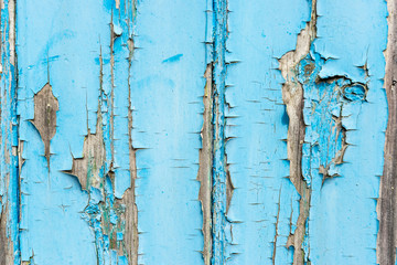 Blue paint flaking off wooden panel background