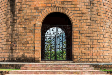 Fototapeta na wymiar Landscape of old brick building with iron gate. They are built in ancient style.