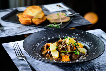 Delicious fish served with tomatoes, lemon and herbs on the wooden board. Top view, flat lay