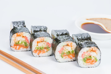 Appetizing fresh set of sushi rolls with rice, shrimps, avocado, cucumber, tobiko and mayonnaise on light background