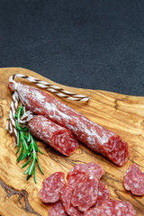 Dried organic salami sausage on wooden cutting board
