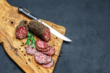 Dried organic salami sausage on wooden cutting board