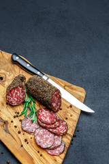 Dried organic salami sausage on wooden cutting board