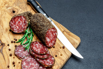 Dried organic salami sausage on wooden cutting board