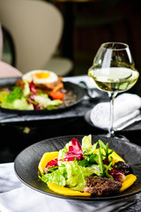 Tasty dish with juicy beef steak and fresh lettuce leaves at a restaurant