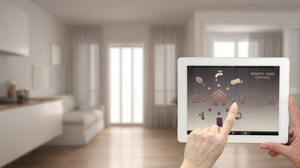 Smart remote home control system on a digital tablet. Device with app icons. Blurry interior of...