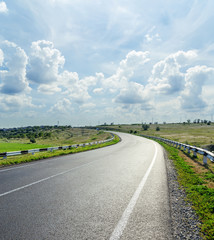 asphalt road and low clouds in blue sky