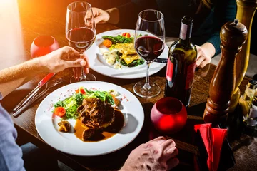 Fotobehang Paar met romantisch diner in een restaurant in stralen van de zon © smspsy