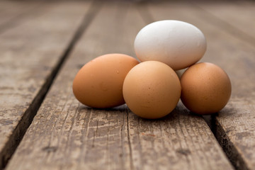 A Pile of Fresh Eggs sitting on a barn wood surface.