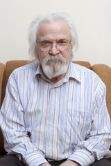 Old sick lonely man in the armchair at home