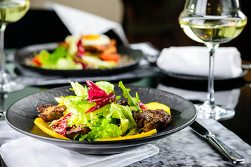 Tasty dish with juicy beef steak and fresh lettuce leaves at a restaurant