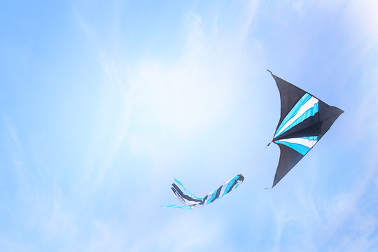 Colorful kite flying in the blue sky through the clouds