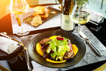 Tasty dish with juicy beef steak and fresh lettuce leaves at a restaurant